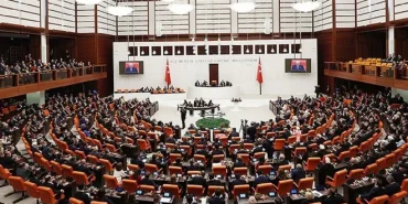 Geçtiğimiz yasama yılında muhalefetin itirazları sonucu 9’uncu Yargı Paketi’nden çıkarılan ve kamuoyunda ‘etki ajanlığı’ olarak nitelendirilen teklif Noterlik Kanunu ve bazı kanunlarda değişiklik yapılmasına dair teklife konulan bir madde ile yeniden Meclis gündemine geldi. TCK’DE YENİ SUÇ İHDASI Teklifin 16. maddesiyle casusluk eylemleriyle daha etkin mücadele edilebilmesi amacıyla Türk Ceza Kanunu'nda yeni bir suç ihdas edildi. DEVLETİN GÜVENLİĞİ, SİYASİ YARARLARI ALEYHİNE SUÇ Teklife ilişkin bilgi notunda, “Devletin güvenliği ile iç veya dış siyasal yararları aleyhine yabancı bir devlet veya organizasyonun stratejik çıkarları veya talimatı doğrultusunda suç işleyenlerin üç yıldan yedi yıla kadar hapis cezasıyla cezalandırılacağı düzenlenmektedir. Böylelikle belge ve bilgi temini veya açıklanması dışında casusluk maksadıyla suç işlenmesi de ayrı bir suç olarak düzenlenmekte ve casusluk faaliyetleriyle daha etkin mücadele edilmesi amaçlanmaktadır” denildi. Notta şu ifadelere yer verildi: "Fiilin savaş sırasında işlenmiş veya Devletin savaş hazırlıklarını veya savaş etkinliğini veya askerî hareketlerini tehlikeyle karşı karşıya bırakmış olması ağırlaştırıcı neden olarak kabul edilmektedir.” TASLAK DEĞİŞTİ Kamuoyuna yansıyan ilk taslakta “Devletin güvenliği veya iç veya dış siyasal yararları aleyhine yabancı bir devlet veya organizasyonun stratejik çıkarları veya talimatı doğrultusunda Türk vatandaşları veya kurum ve kuruluşları ya da Türkiye’de bulunan yabancılar hakkında araştırma yapan veya yaptıranlar, Türkiye’de suç işleyenler” hakkında üç yıldan yedi yıla kadar hapis cezası verileceği ifade edildi. Ancak Meclis Başkanlığı'na sunulan teklifte "Türk vatandaşları veya kurum ve kuruluşları ya da Türkiye’de bulunan yabancılar hakkında araştırma yapan veya yaptıranlar, Türkiye’de suç işleyenler" ifadesi yer almadı. TARTIŞILAN ETKİ AJANLIĞI TAM MADDESİ “Devletin güvenliği veya siyasal yararları aleyhine suç işleme Madde 339/A- (1) Bu Bölümde düzenlenen suçları oluşturmamak kaydıyla, Devletin güvenliği veya iç veya dış siyasal yararları aleyhine yabancı bir devlet veya organizasyonun stratejik çıkarları veya talimatı doğrultusunda suç işleyenler hakkında üç yıldan yedi yıla kadar hapis cezası verilir. Fail hakkında hem bu suçtan hem de işlediği ilgili suçtan dolayı ayrı ayrı cezaya hükmolunur. (2) Fiil, savaş sırasında işlenmiş veya Devletin savaş hazırlıklarını veya savaş etkinliğini veya askerî hareketlerini tehlikeyle karşı karşıya bırakmış ise faile sekiz yıldan oniki yıla kadar hapis cezası verilir. (3) Suçun, milli güvenlik açısından stratejik önemi haiz birimler ile proje, tesis ve hizmetleri yerine getiren kurum ve kuruluşlarda görev yapanlar tarafından işlenmesi halinde verilecek ceza bir kat artırılır. (4) Bu suçtan dolayı kovuşturma yapılması, Adalet Bakanının iznine bağlıdır.”